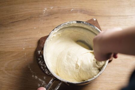 female hands mixing sticky dough, shallow focus