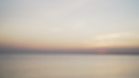 blurred background of peaceful sunset over baltic sea in summer eveningの写真素材