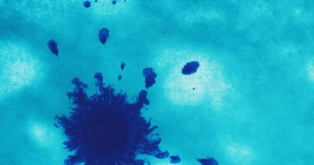 turquoise blue ink drop on wet white paper top viewの写真素材