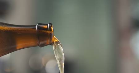 macro wheat beer pouring from brown bottleの写真素材