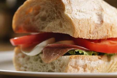 ciabatta sandwich with speck, mozzarella and vegetablesの写真素材