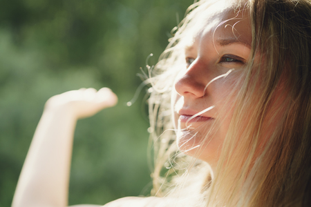 young girl traveling in car portrait with wind blowing her hairの写真素材