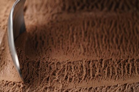 closeup scooping chocolate ice cream with spoonの写真素材