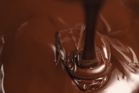 pouring melted premium dark chocolate from aboveの写真素材