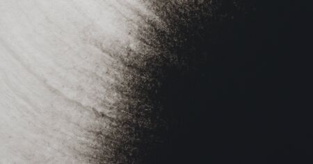 closeup black ink corner spreading on wet paper top viewの写真素材