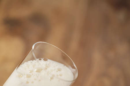 wheat beer poured in glass on wood tableの写真素材