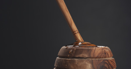 honey pot and dipper with gray background, wide photoの写真素材