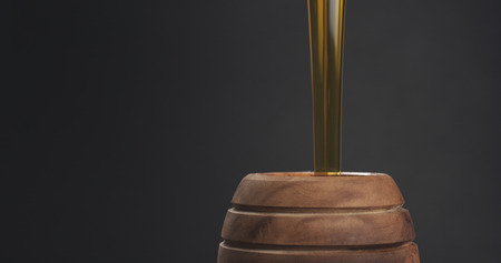 pouring honey in pot closeup, wide photoの写真素材