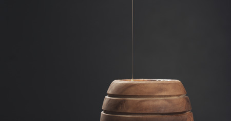 pouring honey in pot closeup, wide photo