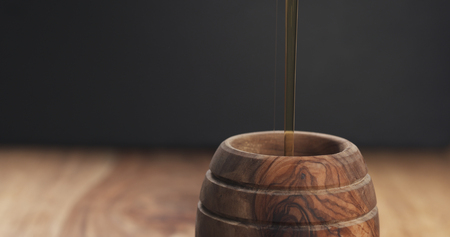 pouring honey in pot closeup, wide photoの写真素材