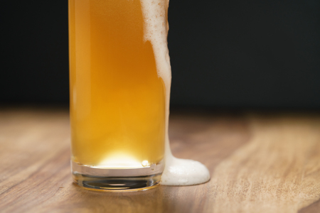 wheat unfiltered beer poured into glass on wood board, with copy spaceの写真素材