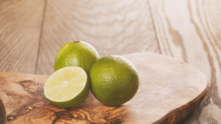 ripe limes on olive boardの写真素材