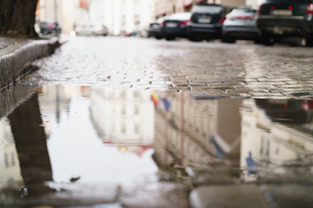 Old wet pavement with puddle in autumn dayの写真素材