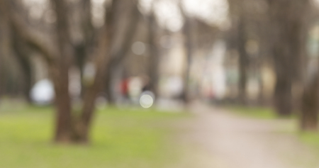 blurred background of traffic in green town at daytimeの写真素材