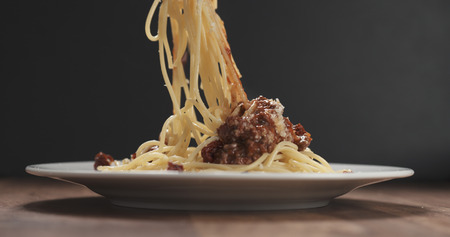 eating spaghetti with bolognese sauce with forkの写真素材