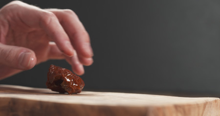 closeup man slicing sundried tomatoesの写真素材