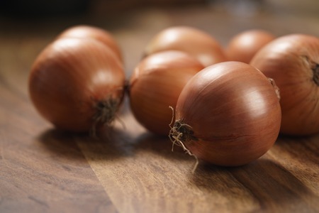brown onions on old wood tableの写真素材