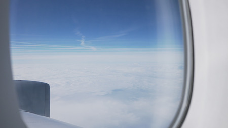 handheld shot view from airplane during flight above the clouds, wide photo