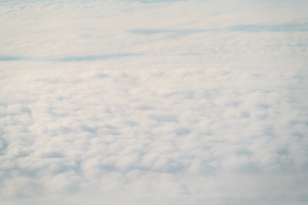 aerial shot from plane flying above the clouds in daytime
