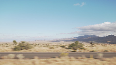 Driving plate side view moving through desert in car with motion blur
