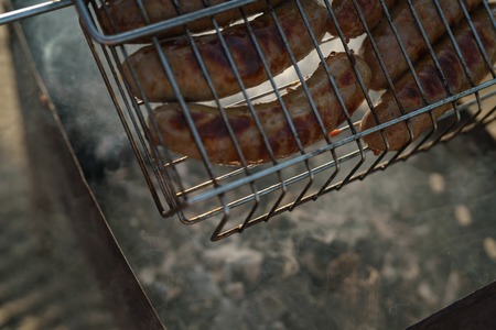 cooking bbq sausages on a beachの写真素材