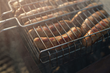 cooking bbq sausages on a beachの写真素材