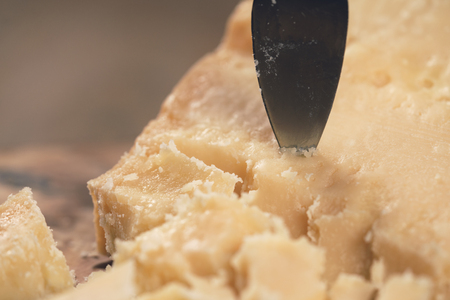 pieces of hard parmesan cheese on olive board from aboveの写真素材