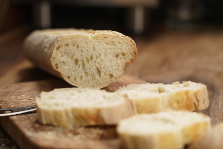Sliced fresh baguette on cutting board closeup