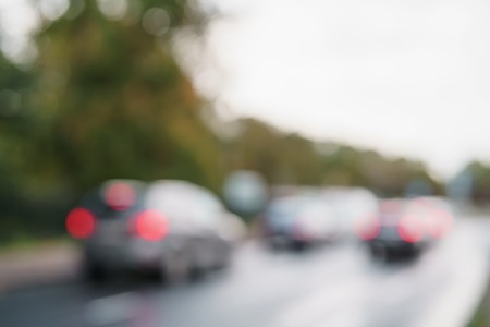 bokeh blur of cars moving on europe city street after rain