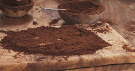 female hands making truffles in cocoa powder on boardの写真素材