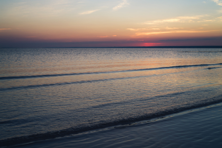 Sunset on beach on Baltic sea with calm water focus close to cameraの写真素材