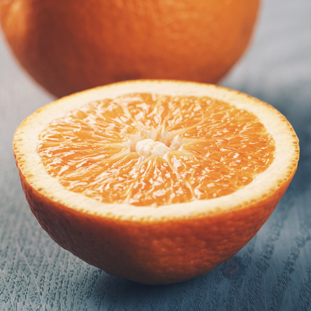 ripe oranges with half sliced on blue wood tableの写真素材