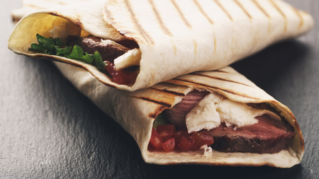 closeup photo of fresh homemade burritos with beef on slate boardの写真素材