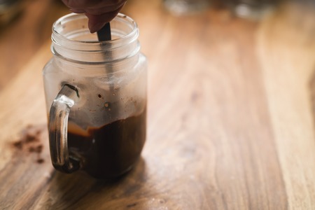 making warm cocoa in glass mug jar on wood tableの写真素材