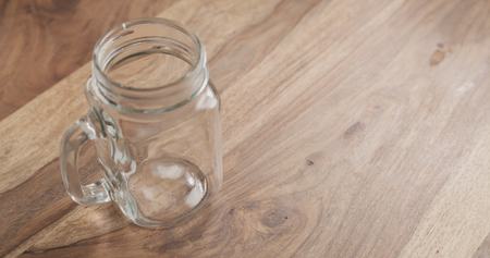 glass jar with handle on wood tableの写真素材