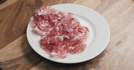 coppa on white plate on wood tableの写真素材