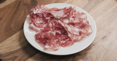 coppa on white plate on wood tableの写真素材