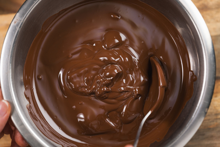 melting dark chocolate in steel bowlの写真素材