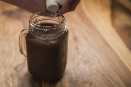 cocoa drink in glass jar with handle on wood tableの写真素材