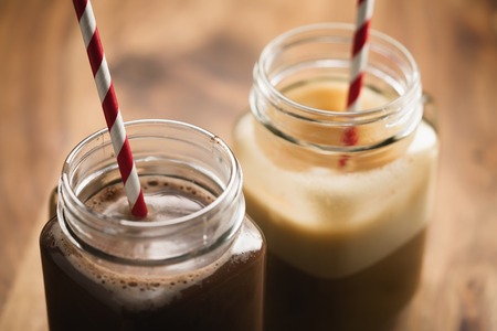 warm cocoa and coffee in jar mugs on a wooden table, shallow focusの写真素材