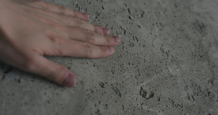 handheld of man hand touching concrete wallの写真素材