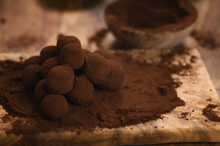 craft chocolate truffles on wooden board with cocoa powderの写真素材