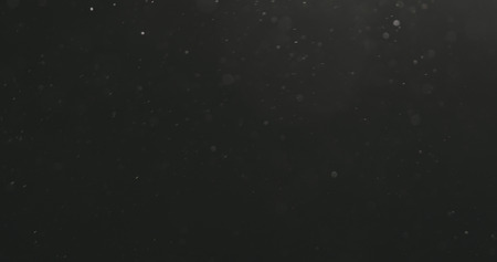 dust particles floating over black background with motion blurの写真素材