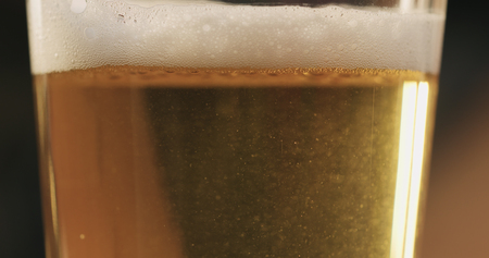 closeup of lager beer pouring in a glassの写真素材