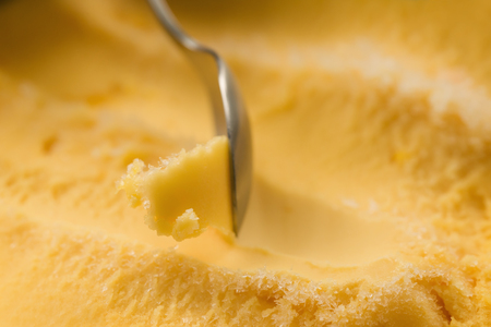 scooping with spoon orange sorbet, closeup photoの写真素材