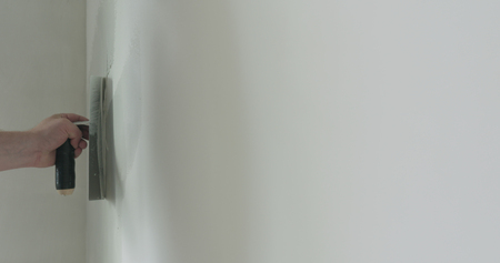 closeup worker applying decorative concrete plaster on the wallの写真素材