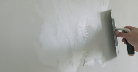 closeup worker applying decorative concrete plaster on the wallの写真素材