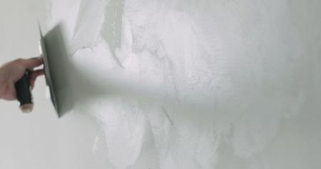 closeup worker applying decorative concrete plaster on the wallの写真素材