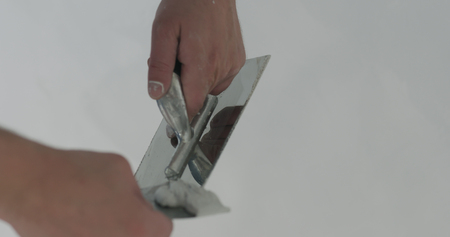 closeup worker cleaning trowel from decorative concrete plasterの写真素材