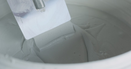 closeup worker dipping the trowel into the decorative concrete plasterの写真素材